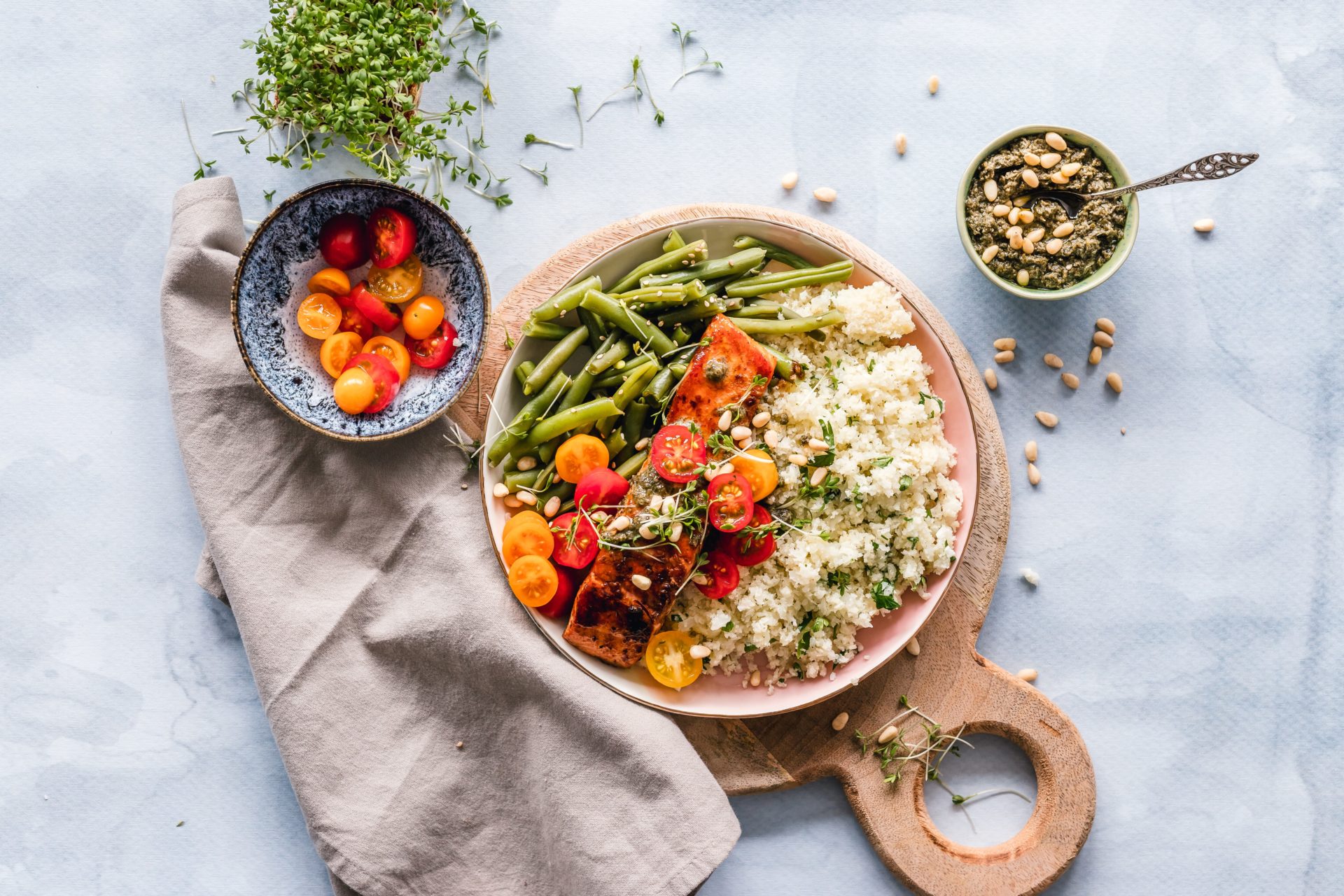 Plate of healthy food including grains, fish, green beans and tomatoes