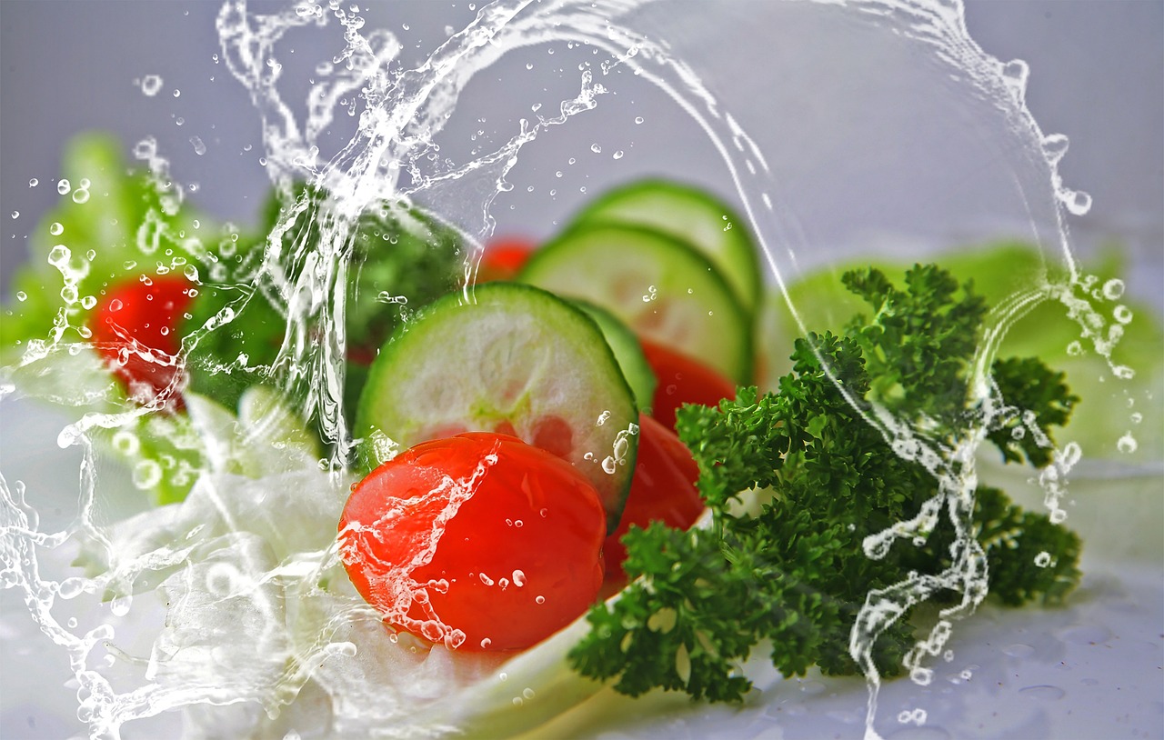 Water splashing over cucumber and tomatoes